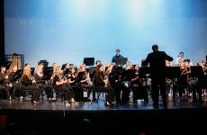 Musical Band performing on stage with a blue backdrop