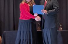 student receives award from man in suit