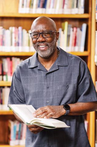 Man dressed nicely wearing glasses and smiling at the camera