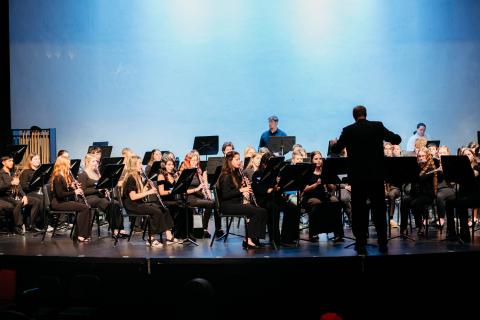 Musical Band performing on stage with a blue backdrop