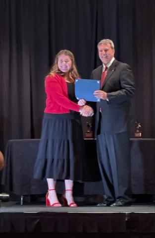 student receives award from man in suit